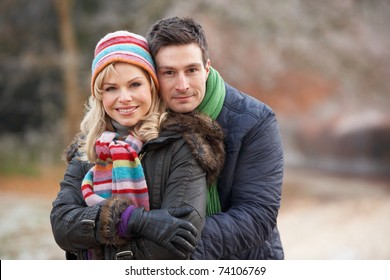 Couple On Romantic Winter Walk Through Frosty Landscape