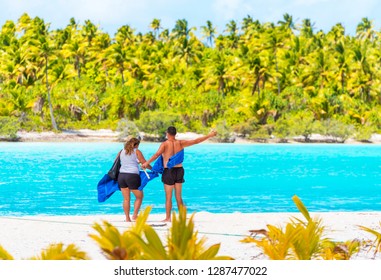 Couple On A Sandy Beach, Aitutaki Island, Cook Islands, South Pacific. With Selective Focus