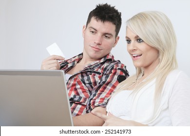 A Couple on sofa with laptop who want to buy something on the Internet.