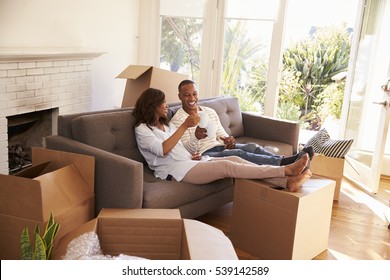 Couple On Sofa Taking A Break From Unpacking On Moving Day - Powered by Shutterstock