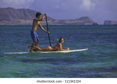 Couple On Stand Up Paddle Board In Hawaii