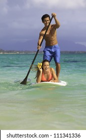 Couple On Stand Up Paddle Board In Hawaii