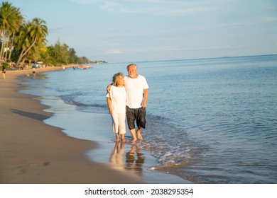 Couple On Summer Beach Vacation, The Healthy Older Couple Running On The Sea Beach, Concept For 
Caring For The Elderly, Caregiving To Older Persons And Relations Of The Family To Support Elderly State