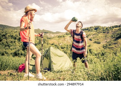 Couple On A Trekking Excursion. Man Refreshing Himself With Water After A Long Walk. Concept About Leisure, Sport And People