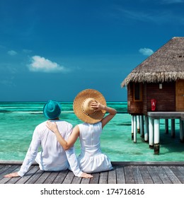 Couple On A Tropical Beach Jetty At Maldives