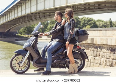 Couple On A Vespa By The River