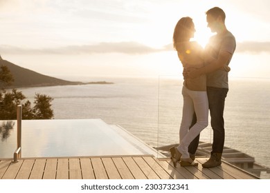 Couple on wooden deck overlooking ocean - Powered by Shutterstock