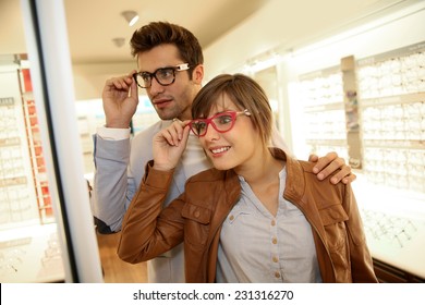 Couple In Optical Shop Choosing Eyeglasses 