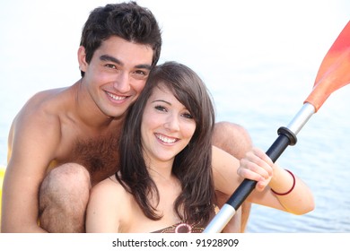 Couple Paddling In Boat