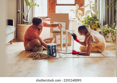 Couple painting wooden table by recycle, donate and thrift furniture for a new home improvement project in new apartment. Creative and DIY man and woman with reusable objects, decorating their house - Powered by Shutterstock