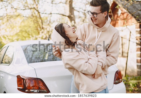 Couple in a park.\
People sitting on the\
hood.