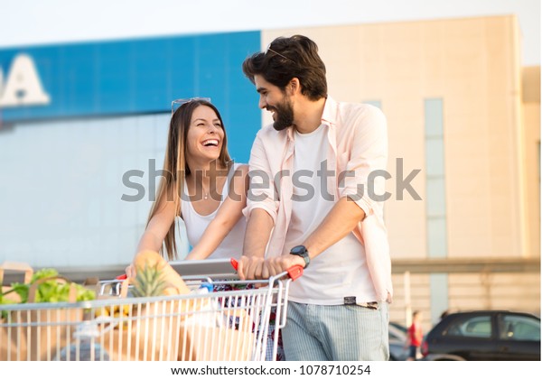 The couple are in the\
parking lot of the shopping center, They have bought everything\
they need.