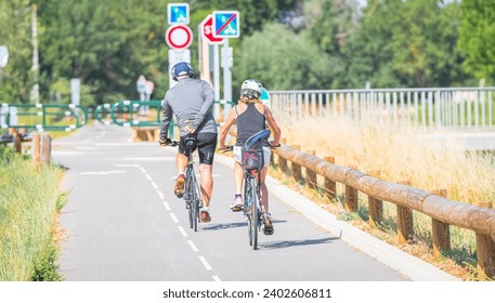 Couple of people cycling on a cycle path.  - Powered by Shutterstock