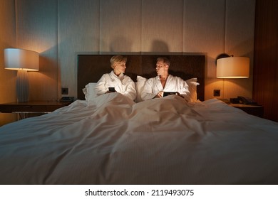 Couple Of People Enjoying The Night In Cozy Hotel Bed