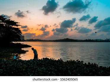 Couple Of People Fishing At The Powai Lake In Evening. Powai Lake Is A Popular Hangout Place In The Suburbs Of Mumbai. Shot This Picture On February 2018.