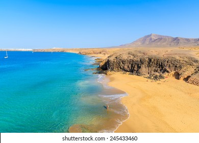 Couple Of People In Turquoise Ocean Water On Papagayo Beach, Lanzarote, Canary Islands, Spain