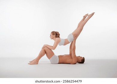 Couple performs acrobatic routine showcasing strength and balance in a studio
