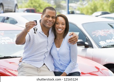 Couple Picking Up New Car From Lot