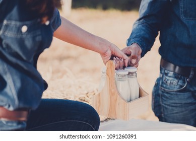 Couple picnic in the summer, woman gives bottle of fresh milk from the farm to her boyfriend - Shutterstock ID 1091260391