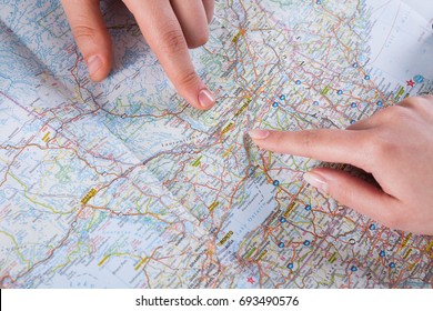 Couple Planning Trip To Montreal, USA, Pointing On This City On Map. Travel Background With Accessories