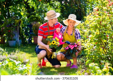 Couple Planting Flowers In Garden