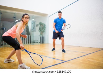 Couple play some squash together in the squash court