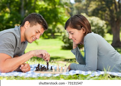 Couple Playing Chess In The Park