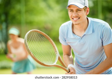 Couple playing doubles at the tennis court. Healthy lifestyle concept.