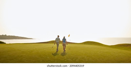 Couple playing golf on course - Powered by Shutterstock