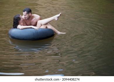 Couple Playing In Inner Tube In River