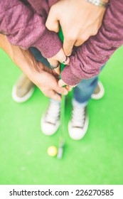 Couple Playing Mini Golf. Man Helping His Girlfriend To Hold The Club. Concept Of Union And Love