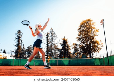 Couple playing recreational tennis on a clay court during the day. - Powered by Shutterstock