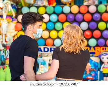 A Couple Playing Shooting Range At An Amusement Park During A Date