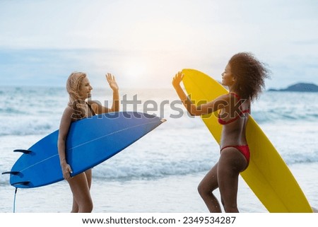 Couple playing surfboard on the beach in weekend activity, Sport extreme healthy lifestyle concept.