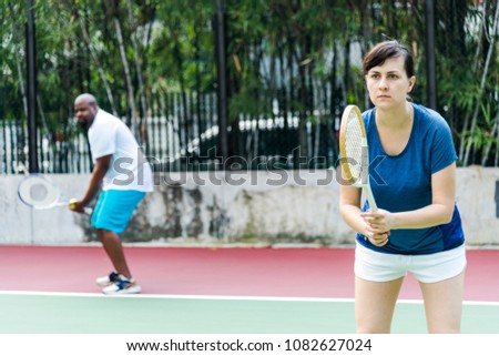 Couple playing tennis as a team