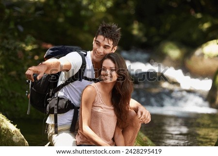 Couple, point and backpack for hiking in jungle with smile for thinking, holiday and search by river. Man, woman and bag for trekking, direction and journey in rainforest for vacation in Colombia