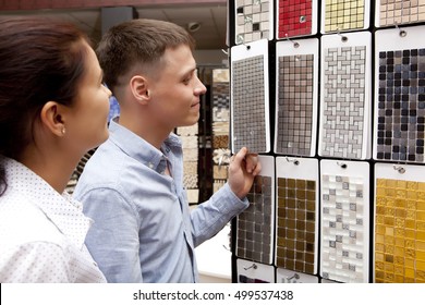 Couple Pointing At Ceramic Mosaic Tile For Bathroom Wall In Store, In Home Improvement Warehouse Exterior