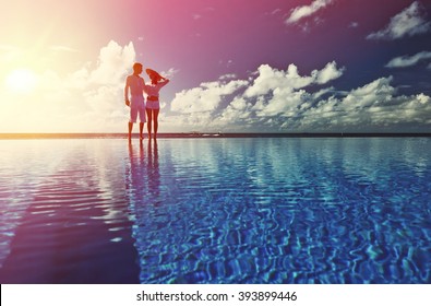 Couple At The Poolside Against Sky