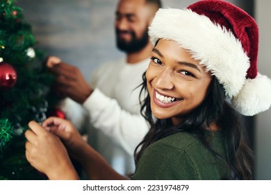 Couple, portrait and christmas tree decor together with love and care during the festive season. Husband, wife and hanging ornaments on an xmas tree while decorating with tinsel and bauble - Powered by Shutterstock