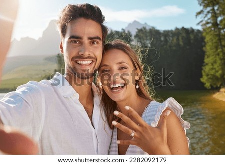 Couple, portrait selfie and engagement by lake for celebration, happiness and excited for future. Man, woman and photography for social media, profile picture and romance for love, proposal and goals