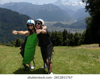 A couple posing before going hang-gliding in the Swiss Alps