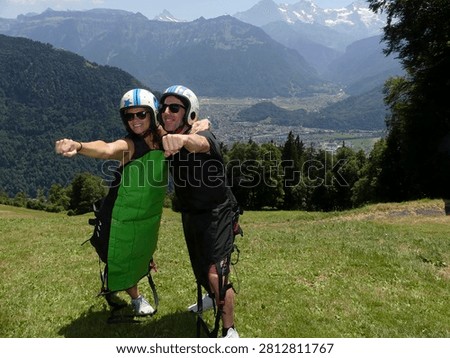 A couple posing before going hang-gliding in the Swiss Alps