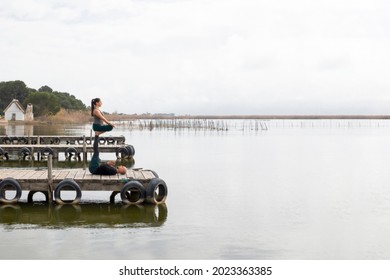 Couple practicing acroyoga in nature, a lake and a wooden dock. Horizontal picture - Powered by Shutterstock