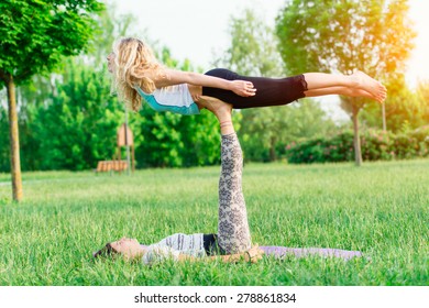 Couple practicing acroyoga in the park - Powered by Shutterstock