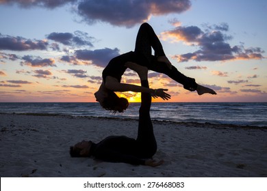 Couple practicing acroyoga at sunrise - Powered by Shutterstock