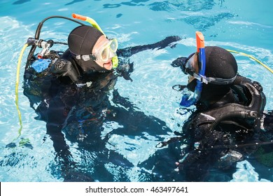 Couple Practicing Scuba Diving Together In The Swimming Pool