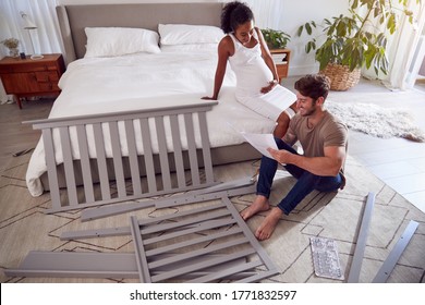 Couple With Pregnant Woman Looking At Instructions For Self Assembly Baby Cot - Powered by Shutterstock