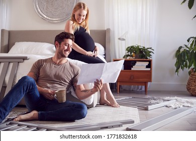 Couple With Pregnant Woman Looking At Instructions For Self Assembly Baby Cot - Powered by Shutterstock