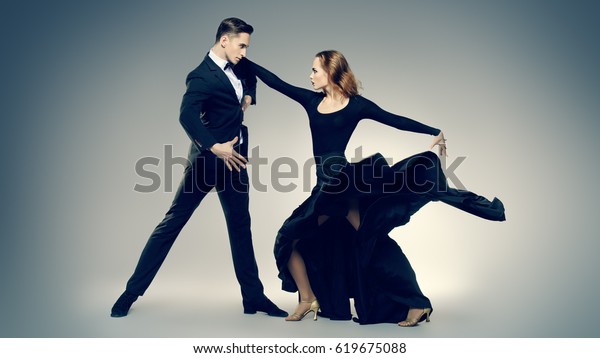 Couple of\
professional dancers performing tango. Beautiful young people in\
love dancing on a date. Studio shot.\
