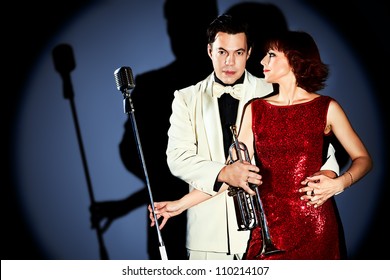 Couple of professional singers in retro style posing in costumes at studio. - Powered by Shutterstock